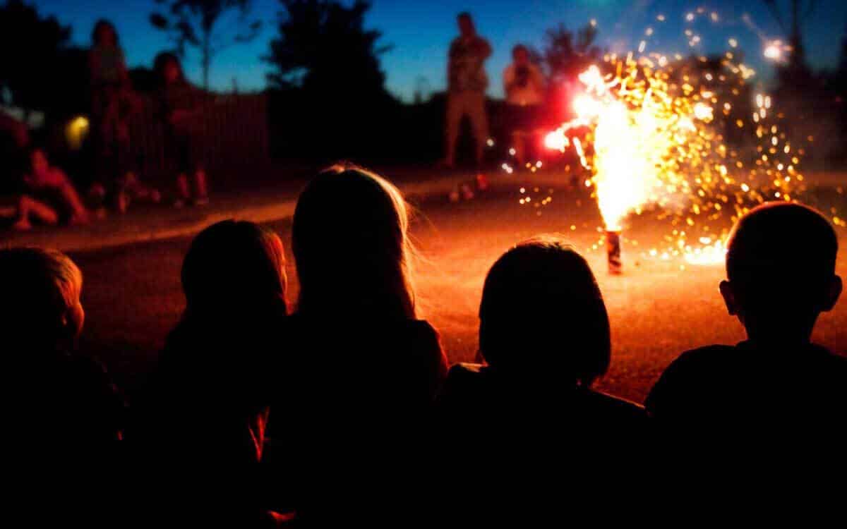 Réveillon dans une copropriété groupe d'enfants fetant le nouvel an et assistent a une scene de feu d'artifice