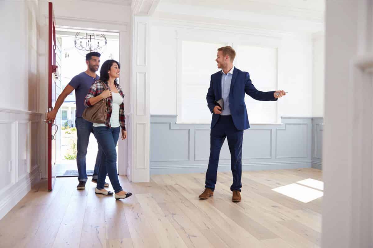 Viste appartement pour location un agent immobilier qui fait visiter un appartement à un couple
